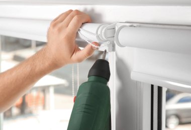 Genç adam pencere perde kapalı yükleme