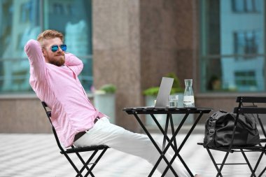 Masada açık havada çalışan dizüstü bilgisayar ile genç blogger