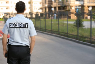 Erkek güvenlik görevlisi açık havada duran