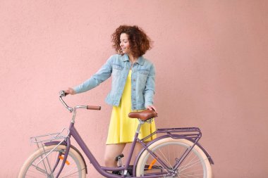 Renk arka plan üzerinde bisiklet ile güzel genç kadın