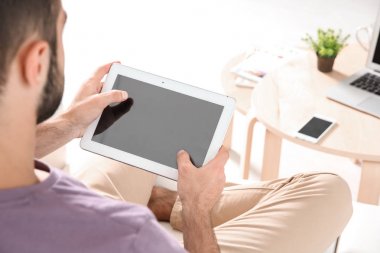 Genç adam evde tablet kullanarak arama bilgileri