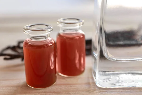 Bottles of vanilla extract on wooden table — Stock Photo, Image