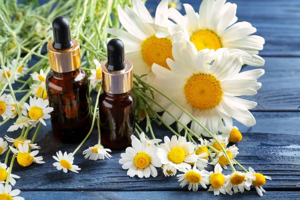 Essential oil and chamomile flowers — Stock Photo, Image