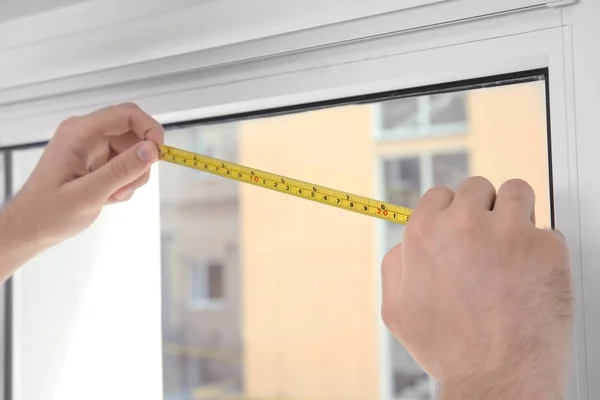 Hombre joven instalando pantallas de ventana en interiores —  Fotos de Stock