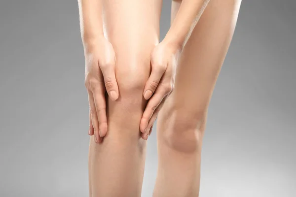 Giovane donna che soffre di dolore alle gambe — Foto Stock