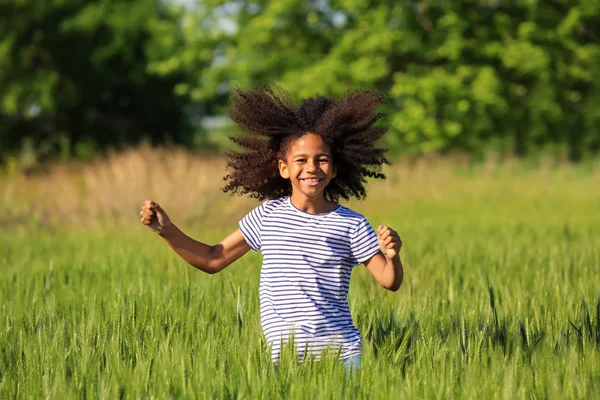 Niña afroamericana en el campo verde — Foto de Stock