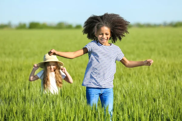 Glückliche kleine Mädchen im grünen Feld — Stockfoto