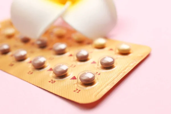 Blistr-antikoncepční pilulky s květinou na barvu pozadí — Stock fotografie