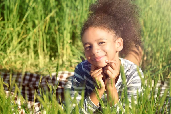 Pequena menina afro-americana em campo verde — Fotografia de Stock