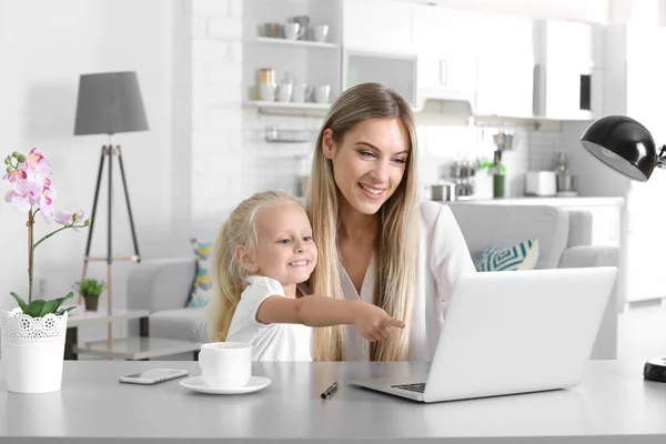 Occupato giovane donna con sua figlia a casa — Foto Stock