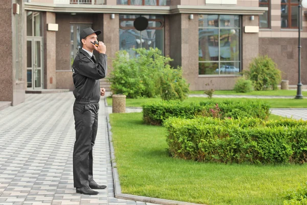 Male security guard with portable radio, outdoors — Stock Photo, Image