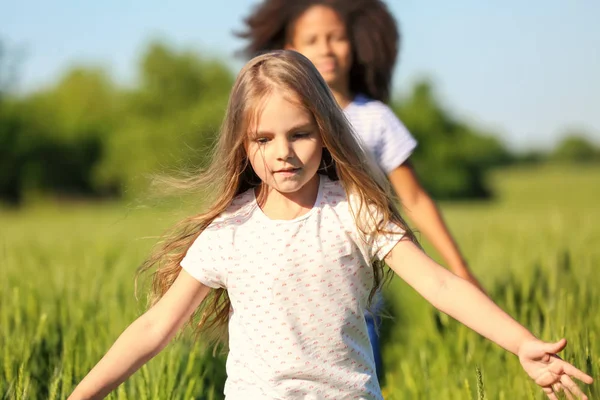 Glückliche kleine Mädchen im grünen Feld — Stockfoto
