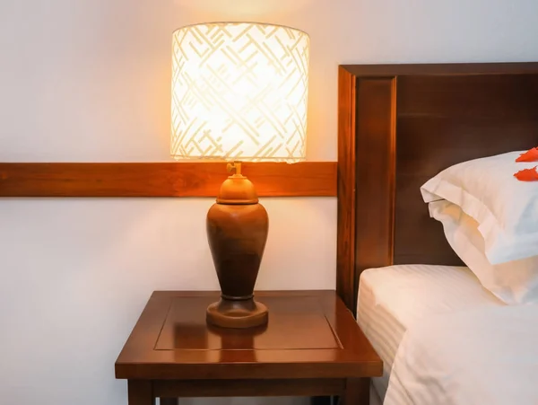 Lamp on night stand in modern hotel room — Stock Photo, Image