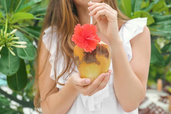 Mujer joven con cóctel de coco fresco en el resort, primer plano — Foto de Stock