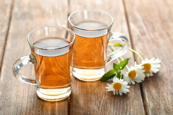 Cups of chamomile tea on wooden background — Stock Photo, Image