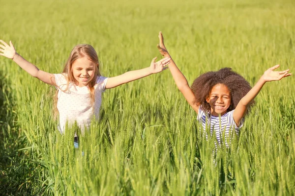 Glückliche kleine Mädchen im grünen Feld — Stockfoto