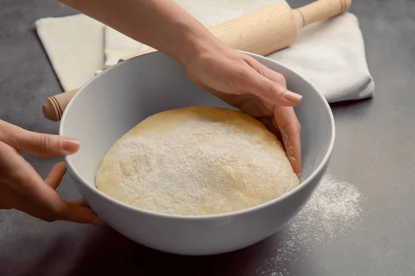 Female chef with dough in bowl on kitchen table — Stock Photo, Image