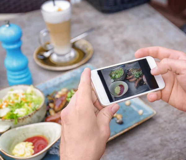 Man photographing tasty food with mobile phone, closeup — Stock Photo, Image