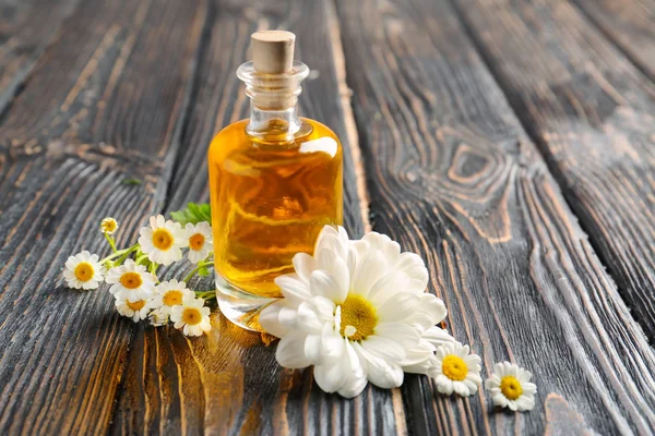 Essential oil and chamomile flowers — Stock Photo, Image