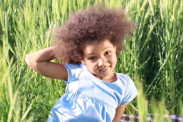 Pequena menina afro-americana em campo verde — Fotografia de Stock