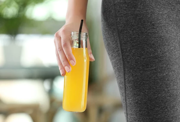 Young woman with bottle of juice at home, closeup. Diet concept — Stock Photo, Image