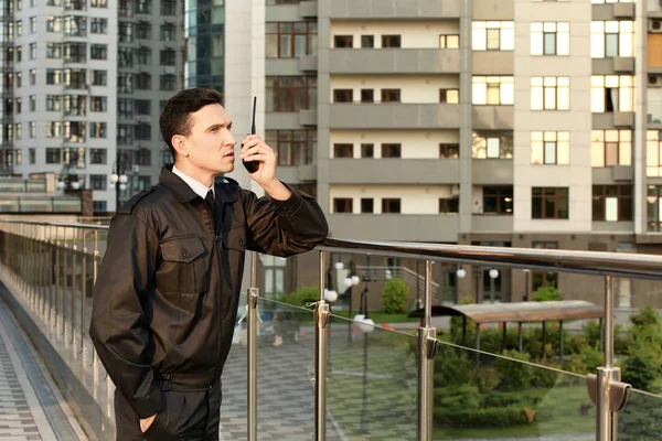 Erkek güvenlik görevlisi ile taşınabilir radyo, açık havada