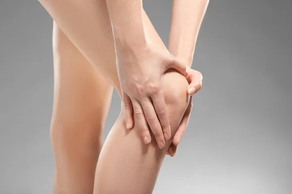 Ung kvinna lider av smärta i benet — Stockfoto