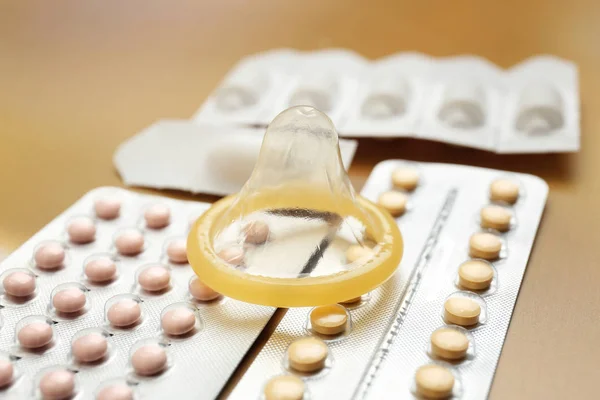 Conceito de contracepção. Comprimidos, preservativo e supositórios vaginais em fundo claro, close-up — Fotografia de Stock