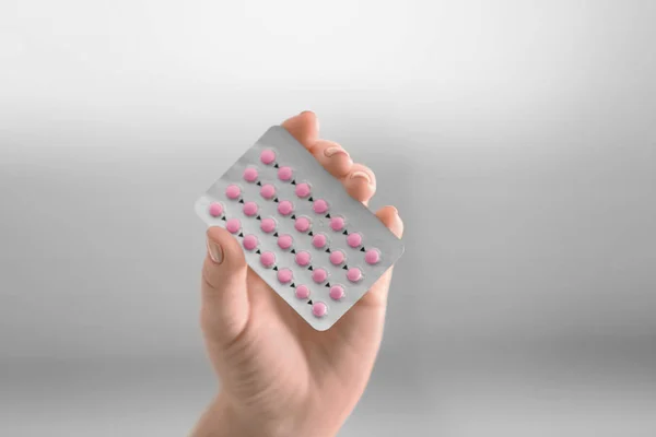 Női kéz a hormonális tabletták elmosódott háttér — Stock Fotó