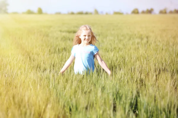 Glückliches kleines Mädchen im grünen Feld — Stockfoto