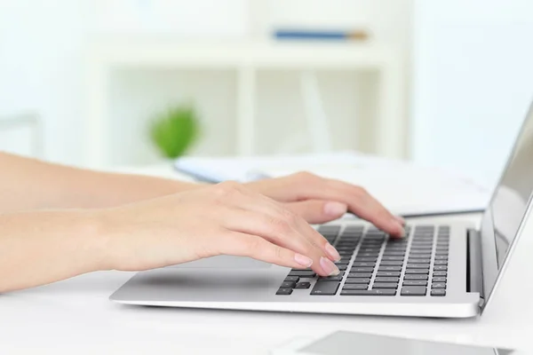 Jovem mulher usando laptop para pesquisar informações na internet à mesa — Fotografia de Stock