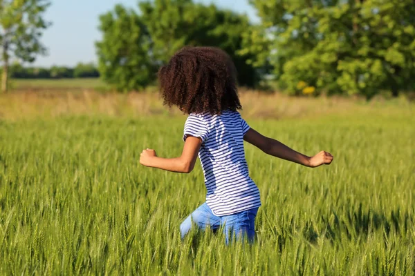 Lite Afro amerikansk flicka i grönt fält — Stockfoto