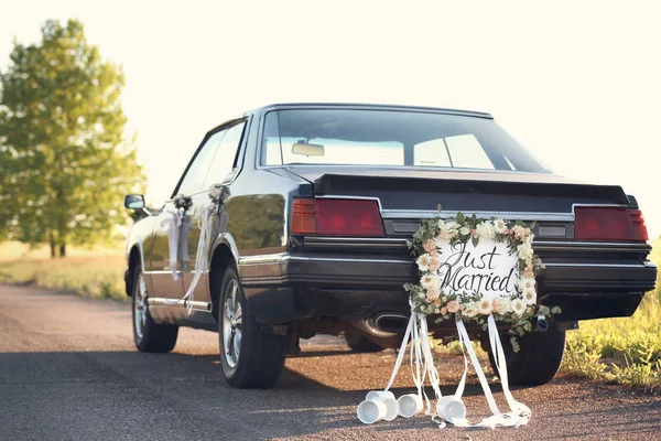 Красивий весільний автомобіль з тарілкою JUST MARRIED і баночками — стокове фото