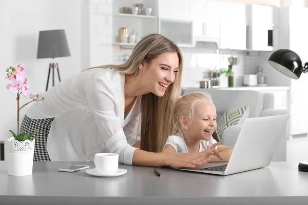 Jeune femme occupée avec sa fille à la maison — Photo