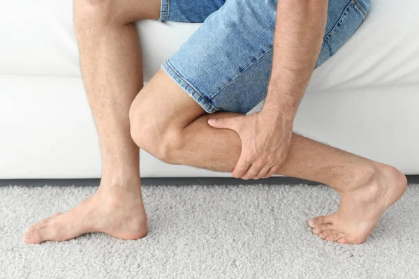 Genç adam evde bacak ağrısı acı — Stok fotoğraf