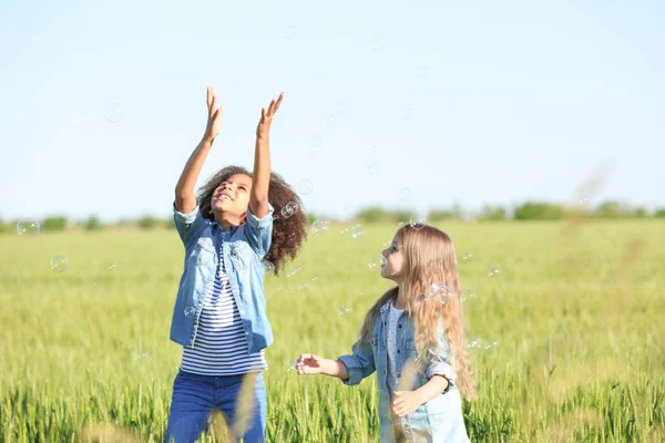 Glückliche kleine Mädchen im grünen Feld — Stockfoto