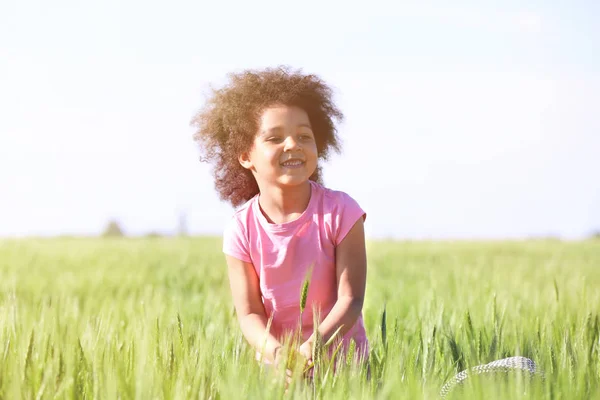 Pequena menina afro-americana em campo verde — Fotografia de Stock