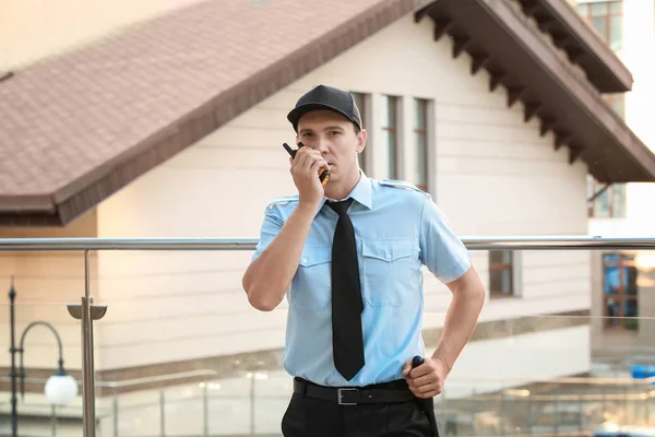 Male security guard with portable radio, outdoors — Stock Photo, Image