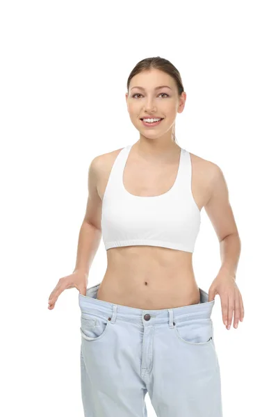 Mulher bonita em jeans oversized no fundo branco. Conceito de dieta — Fotografia de Stock