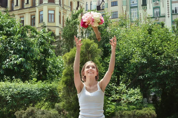 Genç kadın kadar güzel peonies, açık havada buket atma