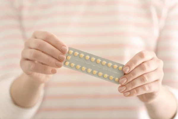 Mulher segurando pílulas hormonais, close-up — Fotografia de Stock