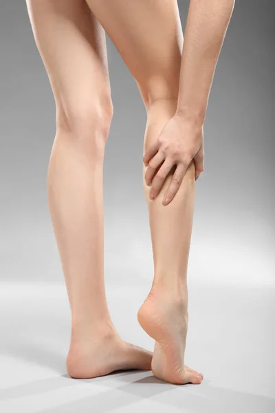 Mujer joven que sufre de dolor en las piernas —  Fotos de Stock