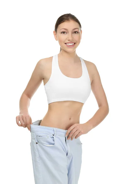 Beautiful young woman in oversized jeans on white background. Diet concept — Stock Photo, Image