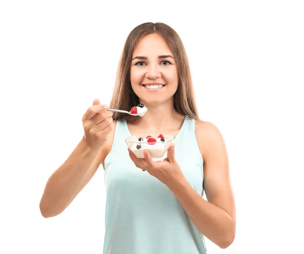 Mujer joven comiendo yogur sobre fondo blanco — Foto de Stock