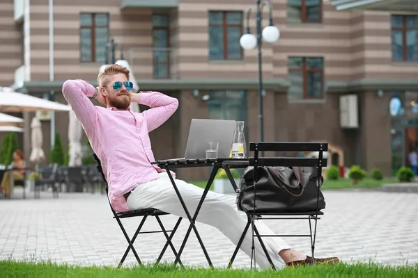 Masada açık havada çalışan dizüstü bilgisayar ile genç blogger