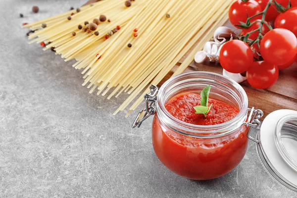 Glazen pot met heerlijke tomatensaus en pasta — Stockfoto