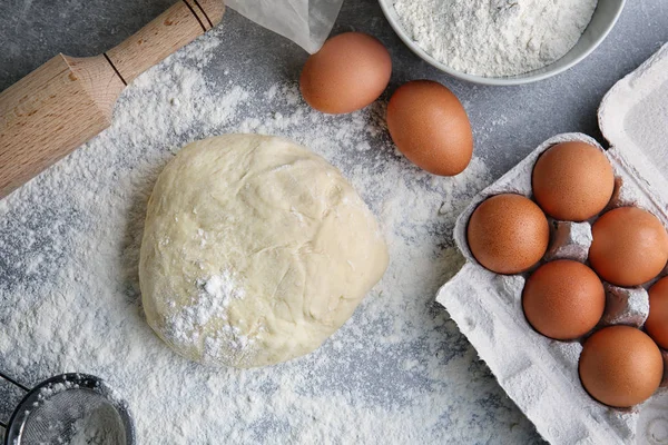 Raw dough, eggs and rolling pin — Stock Photo, Image