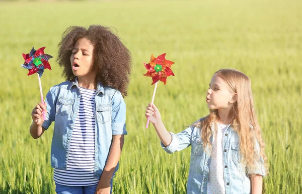 Oyuncak yel değirmenleri yeşil alan ile mutlu küçük kızlar