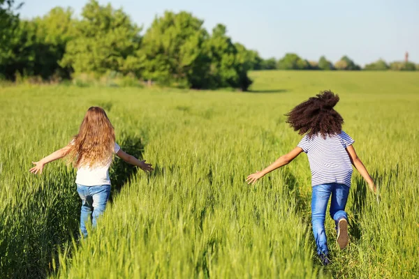 Glückliche kleine Mädchen im grünen Feld — Stockfoto