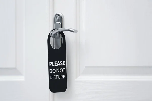 Closed door with sign PLEASE DO NOT DISTURB on handle at hotel — Stock Photo, Image